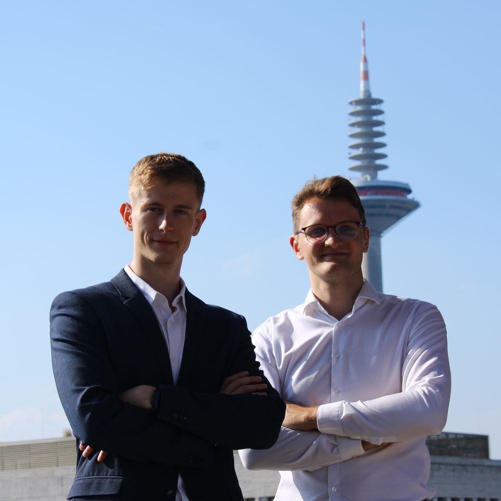 Die Gründer Steven Siebert und Lars Weidner auf einer Terrasse in Frankfurt, im Hintergrund der Europaturm